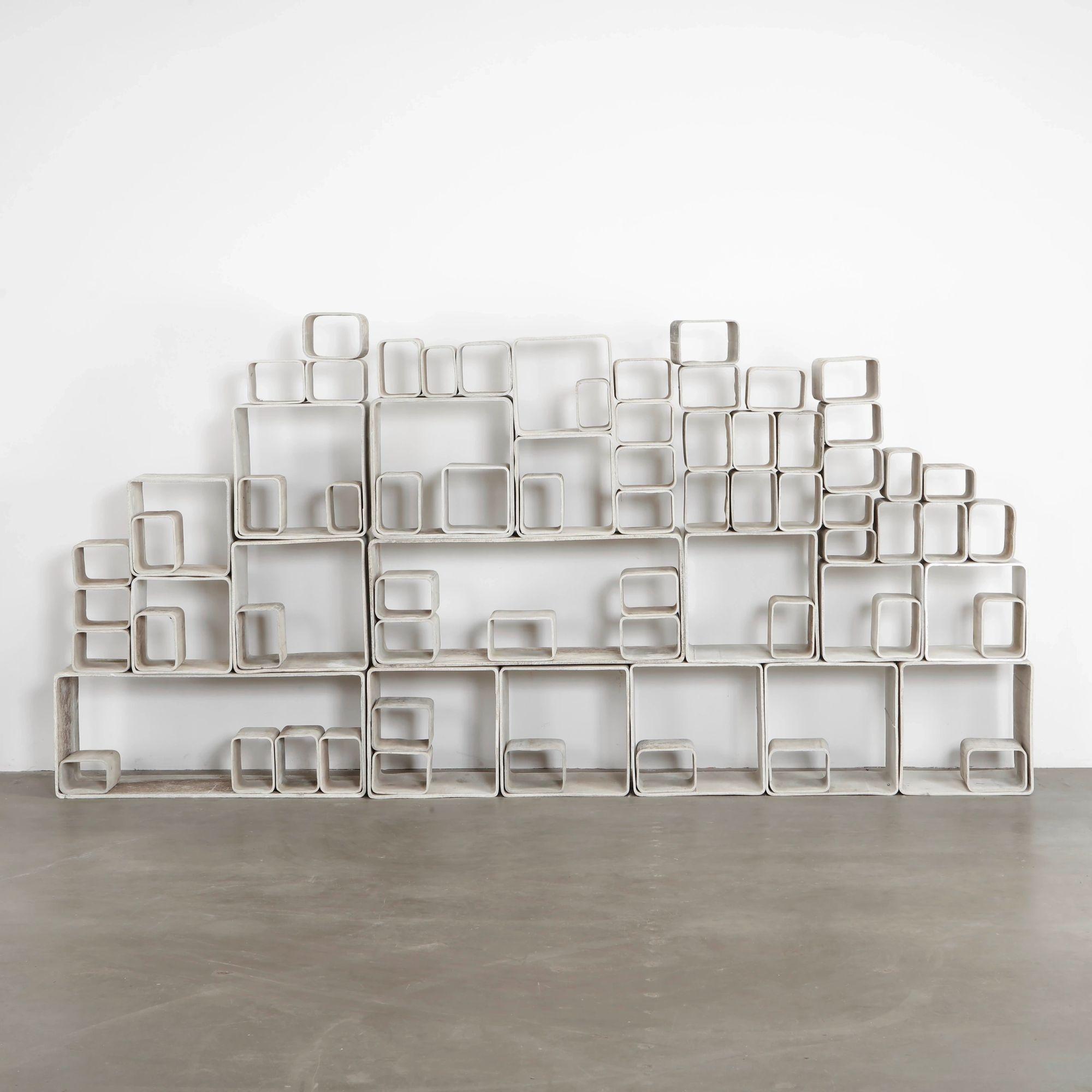 Willy Guhl modular concrete bookcase standing against a white wall on the Mission Road showroom floor