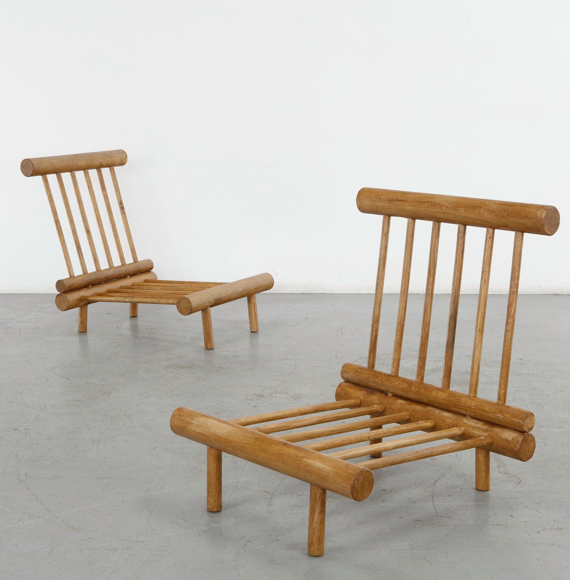 Pair of Charlotte Perriand La Cachette fireside chairs in solid oak with cylindrical uprights and slatted seats